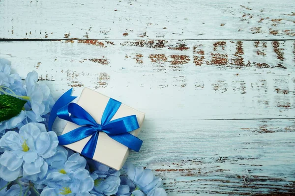 Blue Gift Box and flower decoration on wooden background