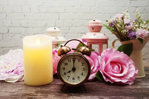 Candles and alarm clock interior decoration on white brick wall background