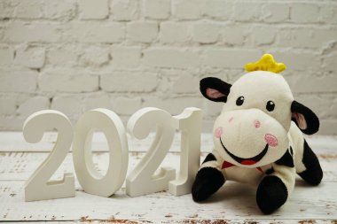 2021 Mutlu Yıllar ve Beyaz tuğla duvarında uzay kopyası olan şirin inek bebek ve ahşap arka plan