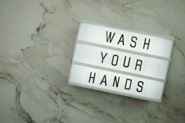 Düz bir şekilde ellerini yıka ve ışık kutusunda mermer arka planda yer nazlı bir şekilde ellerini yıka.