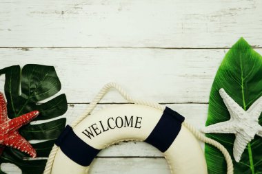 Yeşil izinli yaz konsepti, deniz yıldızı ve ahşap arka planda lifbuoy dekorasyonu.