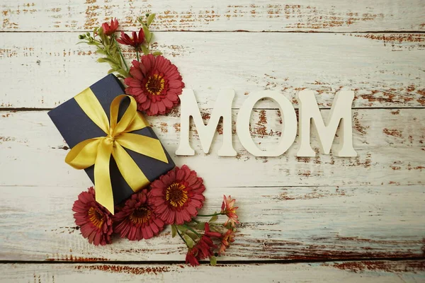 母の日の背景とアルファベット母の手紙と花とギフトボックス木製の背景 — ストック写真
