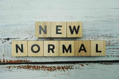 Ahşap arkaplanda Yeni Normal alfabe harfleri