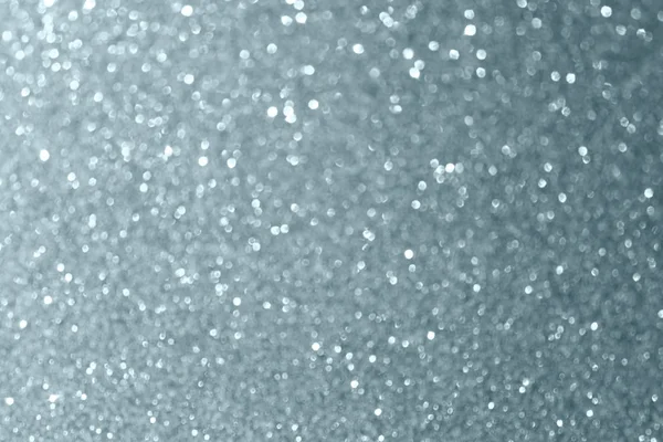 Abstract silver glitter or blur light effect background. Glittering silver grain or shining particles texture with sparkling snow lights for modern trendy Christmas background design template