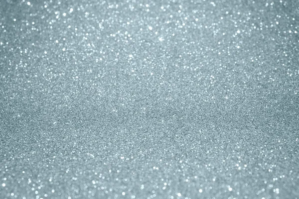 Stříbrné třpytky textury pozadí s rozostření světelný efekt a lesklé jiskřivé částečky. Třpytivé stříbrné nebo zářící sněhu světla pro moderní trendy slavnostní Vánoční pozadí šablony návrhu — Stock fotografie