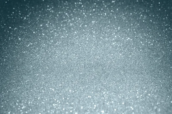 Brilho de prata e efeito de luz bokeh borrão cintilante no fundo branco da neve. Brilhante prata ou partículas brilhantes textura com luz cintilante para moderno modelo de design de fundo de Natal — Fotografia de Stock