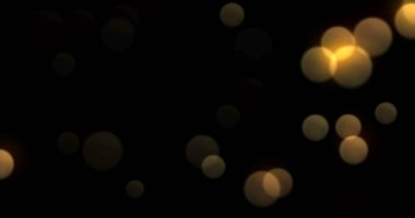 Bokeh hafif arka plan, altın rengi parlak soyut aydınlatma efekti. Altın sarısı ışıltılı parçacıklar, parlak, parlak ışık saçan siyah arka planda parıldıyor.