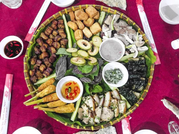 Vietnamese traditional variety food is presented on a bamboo plate for tourists to enjoy