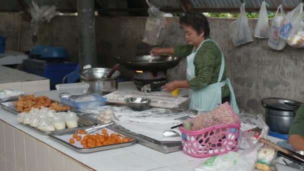Koh Samui, Thailand-juli 2016: vrouw bereidt gebakken voedsel op straat — Stockvideo