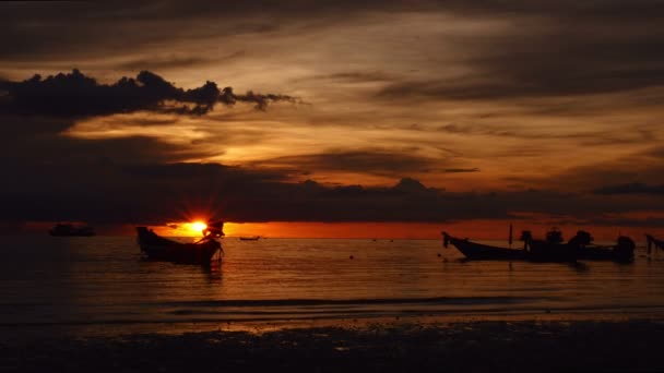 Soluppgång på en tropisk strand. siluetter av båtar och människor, sand och hav. — Stockvideo
