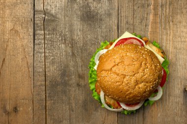 Üstten Görünüm gurme hamburger ahşap arka plan üzerinde. Fastfood yemek.