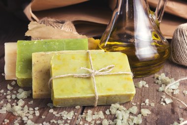 El yapımı, doğal organik sabun ve ahşap arka plan üzerinde Kozmetik yağı topluluğu. Spa Ürünleri. Mor ve renkli vintage