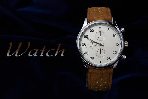 Relógio de pulso masculino com pulseira de couro marrom closeup em um fundo azul escuro com lugar para o seu texto Imagem De Stock