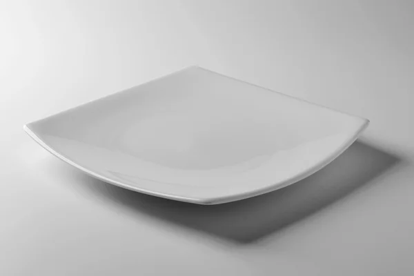 Assiette simple carrée blanche sur table blanche — Photo