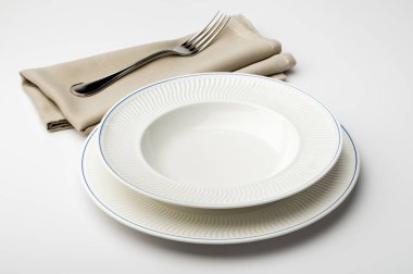 Yuvarlak beyaz tabak boş ve peçete ve çatal ile kase