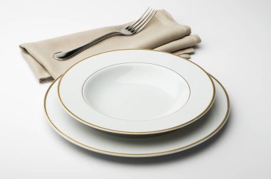 Yuvarlak beyaz tabak boş ve peçete ve çatal ile kase