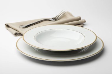 Yuvarlak beyaz tabak boş ve peçete ve çatal ile kase