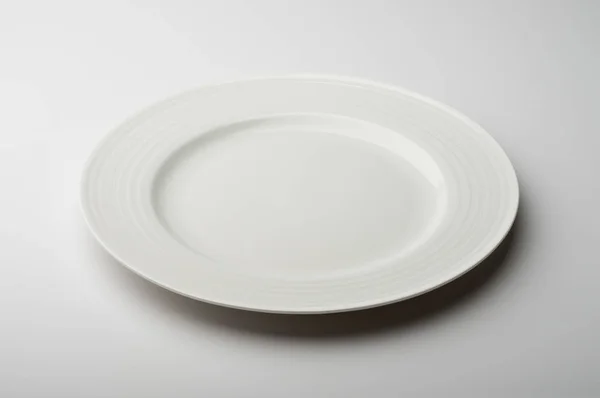 Empty round white plate with decorated border — Stock Photo, Image