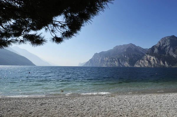 Gardasjön och bergen sett från Torbole stranden — Stockfoto