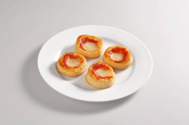 Dört küçük pizza ile yuvarlak tabak