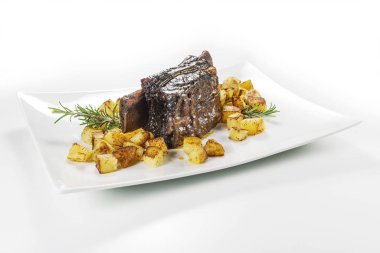 Dikdörtgen beyaz tabak pişmiş biftek kaburga ve kavrulmuş patates ile