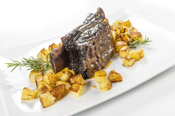 Dikdörtgen beyaz tabak pişmiş biftek kaburga ve kavrulmuş patates ile