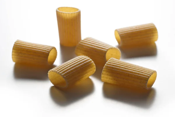 Alcuni pezzi di pasta integrale maccheroni isolati su dorso bianco — Foto Stock