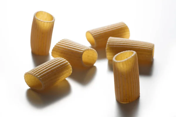 Alcuni pezzi di pasta integrale maccheroni isolati su dorso bianco — Foto Stock