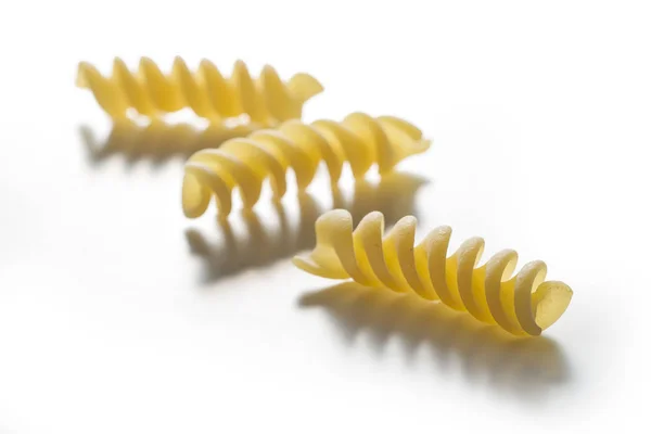 Três pedaços de massa Fusilli isolada sobre fundo branco — Fotografia de Stock