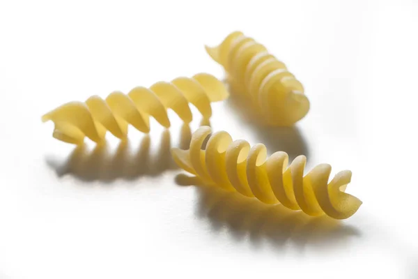Три шматочки макаронних виробів Fusilli ізольовані на білому тлі — стокове фото