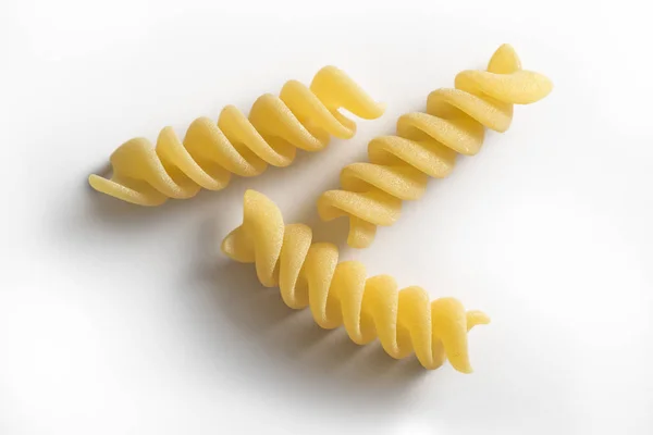 Três pedaços de massa Fusilli isolada sobre fundo branco — Fotografia de Stock