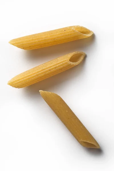 Tři kusy celozrné těstoviny Penne izolovaných na bílém poz — Stock fotografie