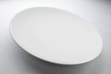 Masa örtüsü ile tabloda boş beyaz yuvarlak tabak