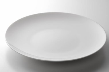 Beyaz masada boş beyaz yuvarlak tabak