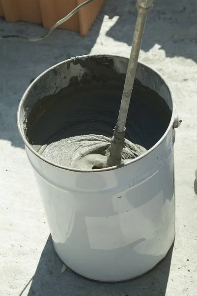 Bucket with mixing of adhesive on construction site — Stock Photo, Image