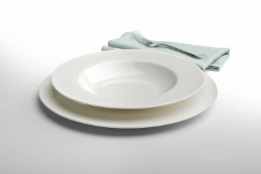 Yuvarlak beyaz tabak boş ve peçete ve çatal ile kase