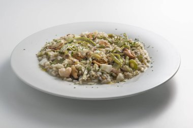 Risotto enginar ve deniz ürünleri ile yuvarlak beyaz tabak