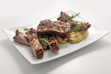 Pişmiş domuz kaburga ve Mısır unu lapa ile beyaz dikdörtgen plaka