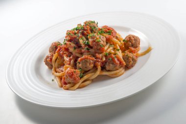 Bir tabak domatesli spagetti ve doğranmış köfte.