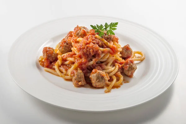 Plate of spaghetti with tomato and meatballs with parsley leaves Royalty Free Stock Images