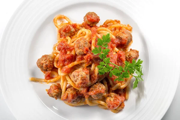 Plate of spaghetti with tomato and meatballs with parsley leaves Stock Picture