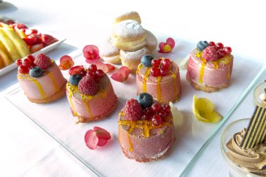 Tatlı büfesi tepsisinin küçük porsiyonlu çilekli cheesecake