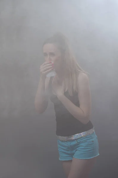 La fille étouffe de fumée épaisse Image En Vente