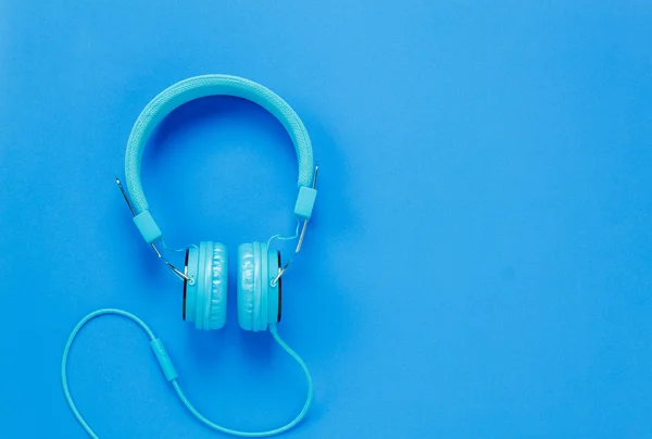 Vista superior auriculares azules sobre fondo azul con espacio de copia . —  Fotos de Stock