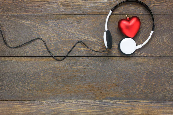Üstten Görünüm kırmızı kalp şekli ahşap üzerine kulaklık ile müzik dinleme