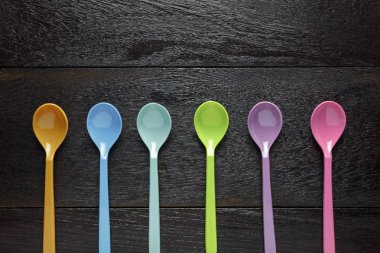 Üstten Görünüm renkli plastik kaşık ahşap masa.