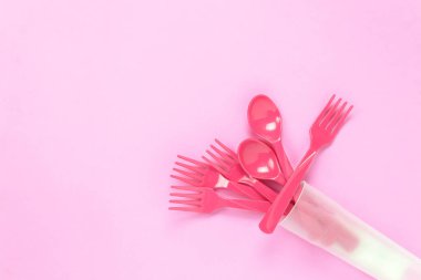 Pembe tablo arka plan üzerinde renkli plastik kaşıkla Üstten Görünüm