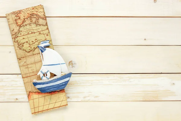 Top view essential travel items.The boat map  on white  wooden b