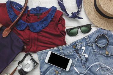 Üstten Görünüm teknoloji arka plan kavramı ile seyahat için kadın giyim aksesuarları. Temel öğeleri seyahat edenler için ya da genç ve yetişkin tatil gezi için hazır olun. Birkaç modern beyaz tahtaya nesne.