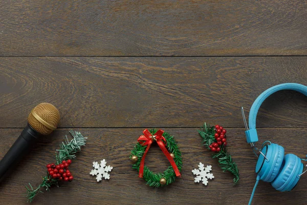 Above view of ornaments & decorations Happy new year and Merry Christmas with music concept.Mix objects composition on the modern rustic brown wooden at home office desk.Free space for creative font.